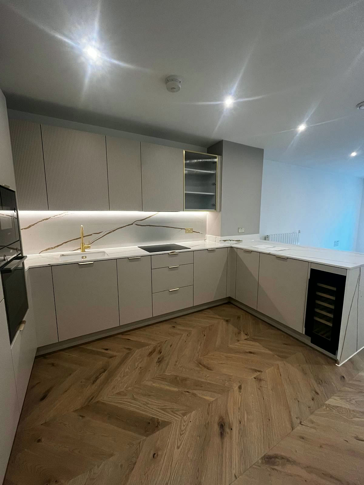 L-shaped kitchen with under-cabinet lighting and wine cooler