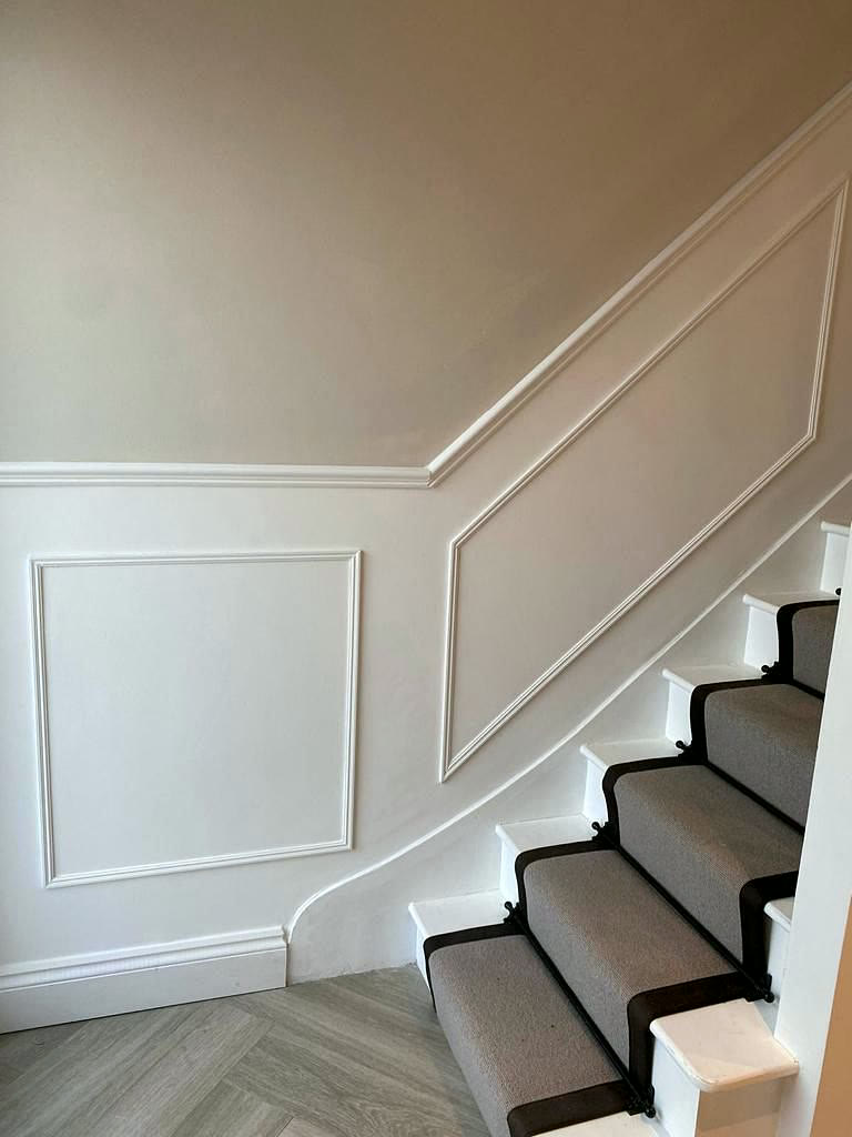Staircase with wall panelling and herringbone floor